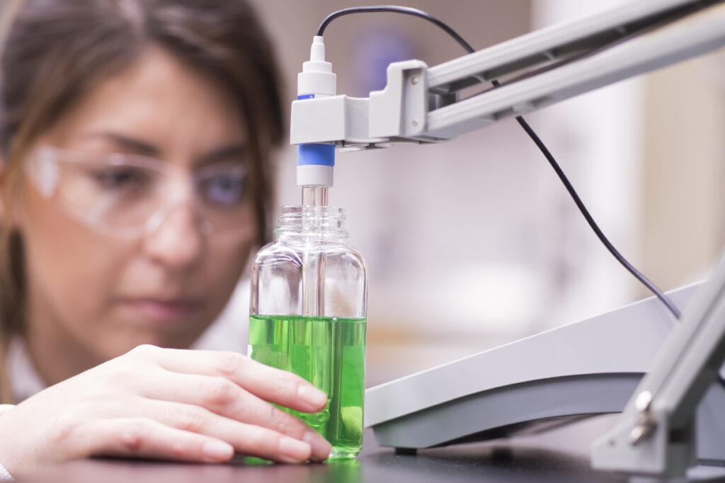 Women Scientist testing green liquid